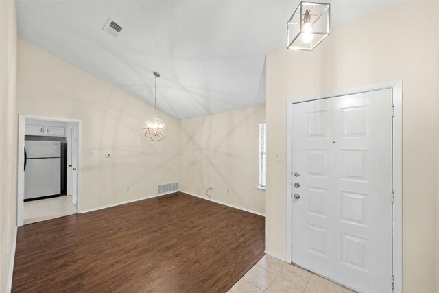 11921 Tanglebriar Trl, Austin, TX 78750 - foyer entrance with vaulted ceiling, wood finished floors, a chandelier, and baseboards