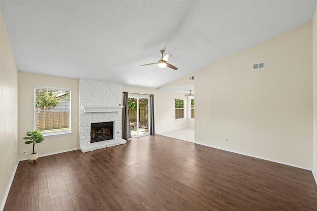 11921 Tanglebriar Trl, Austin, TX 78750 - unfurnished living room featuring ceiling fan, a fireplace, wood finished floors, vaulted ceiling, and baseboards