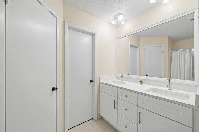 11921 Tanglebriar Trl, Austin, TX 78750 - bathroom with a textured ceiling, double vanity, tile patterned flooring, and a shower with curtain