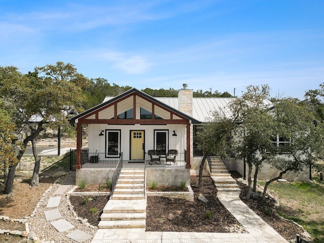 631 Lakeside Dr, Wimberley, TX 78676 - bungalow featuring stairway, board and batten siding, covered porch, metal roof, and a chimney