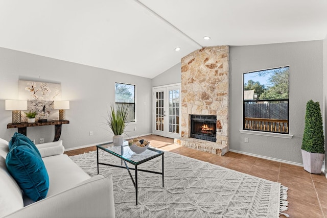 living area with a fireplace, lofted ceiling, tile patterned flooring, and baseboards