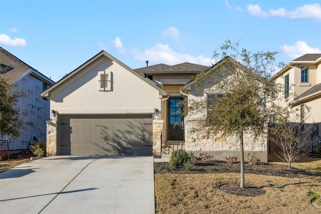 view of front of property with stucco siding, driveway, stone siding, and an attached garage
