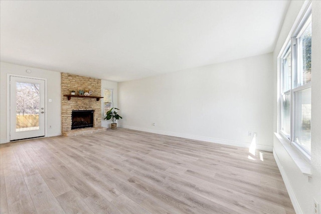 8011 Scotland Yard, Austin, TX 78759 - unfurnished living room with plenty of natural light, light wood-type flooring, a fireplace, and baseboards