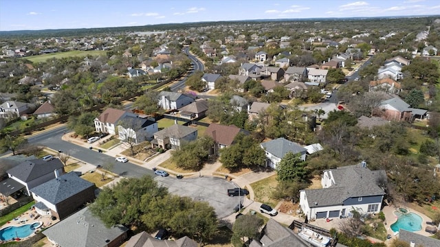 aerial view of property and surrounding area with a pool area and nearby suburban area