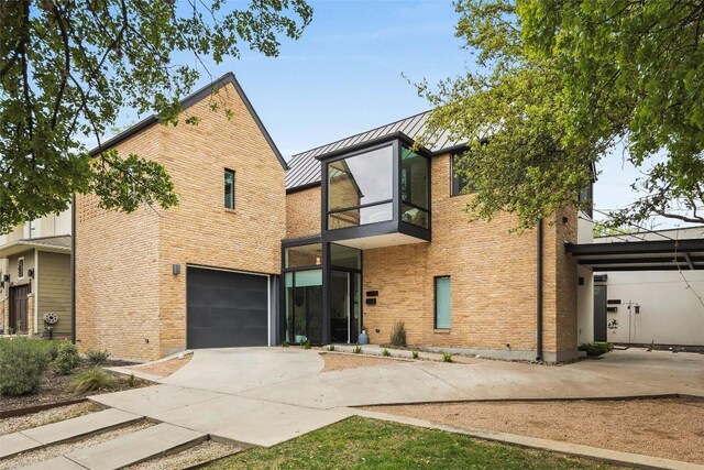 2012 Arpdale St, Austin, TX 78704 - contemporary home with a standing seam roof, driveway, a garage, a metal roof, and brick siding