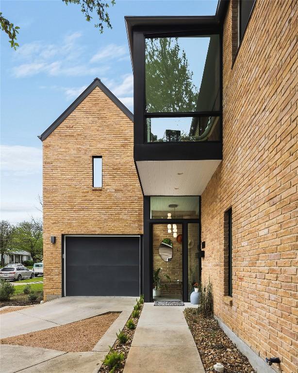 2012 Arpdale St, Austin, TX 78704 - entrance to property featuring driveway, a garage, and brick siding