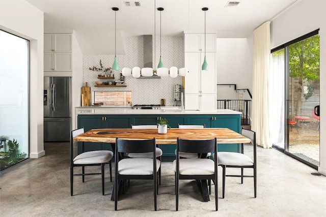 2012 Arpdale St, Austin, TX 78704 - kitchen featuring stainless steel fridge, a kitchen island with sink, concrete floors, tasteful backsplash, and wall chimney range hood
