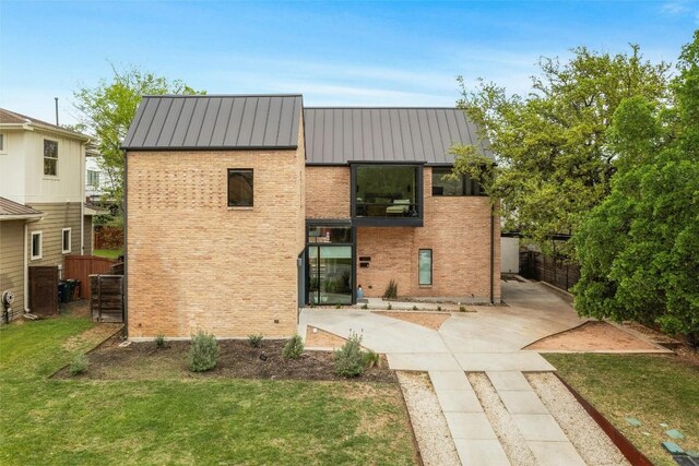 2012 Arpdale St, Austin, TX 78704 - back of property with a standing seam roof, brick siding, a metal roof, and a balcony