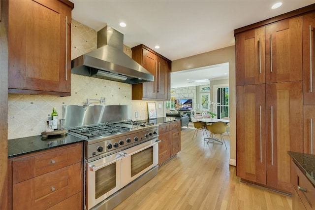 2208 Mountain View Rd, Austin, TX 78703 - kitchen featuring double oven range, wall chimney exhaust hood, light wood-style flooring, brown cabinetry, and recessed lighting