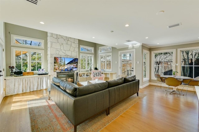 2208 Mountain View Rd, Austin, TX 78703 - living area featuring wood finished floors, recessed lighting, crown molding, a stone fireplace, and baseboards