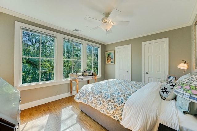 2208 Mountain View Rd, Austin, TX 78703 - bedroom with multiple windows, light wood-style flooring, baseboards, crown molding, and multiple closets