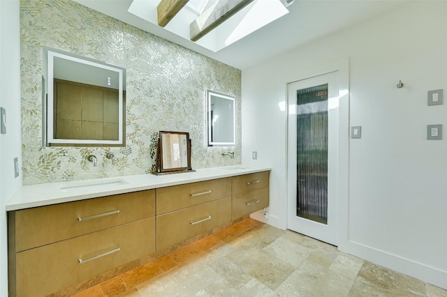 2208 Mountain View Rd, Austin, TX 78703 - full bath with double vanity, wallpapered walls, a skylight, stone finish floors, and baseboards