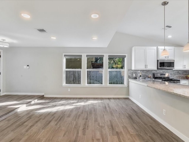 10310 Bilbrook Pl, Austin, TX 78748 - kitchen with stainless steel appliances, white cabinetry, backsplash, light wood finished floors, and vaulted ceiling