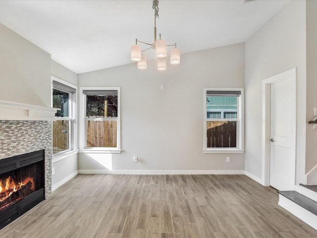 10310 Bilbrook Pl, Austin, TX 78748 - unfurnished living room featuring lofted ceiling, light wood finished floors, a chandelier, and a tiled fireplace