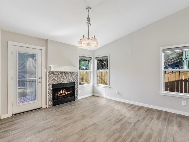10310 Bilbrook Pl, Austin, TX 78748 - unfurnished living room featuring wood finished floors, a chandelier, a tile fireplace, and lofted ceiling