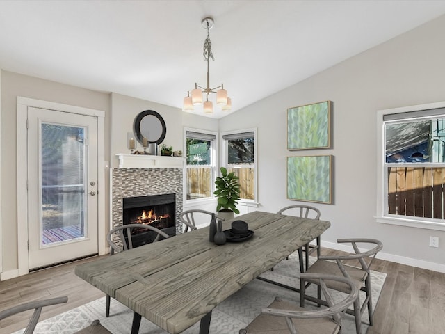 10310 Bilbrook Pl, Austin, TX 78748 - dining space with a chandelier, a tile fireplace, wood finished floors, and vaulted ceiling