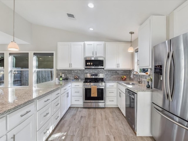 10310 Bilbrook Pl, Austin, TX 78748 - kitchen with stainless steel appliances, lofted ceiling, white cabinets, decorative backsplash, and light stone counters