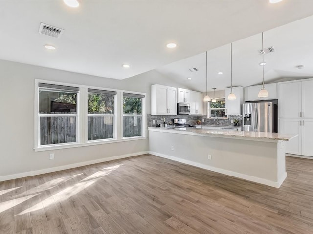 10310 Bilbrook Pl, Austin, TX 78748 - kitchen with stainless steel appliances, lofted ceiling, white cabinetry, backsplash, and a peninsula