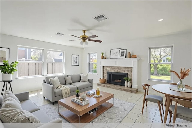 8521 Racine Trl, Austin, TX 78717 - living room with healthy amount of natural light, a ceiling fan, light tile patterned flooring, and a stone fireplace