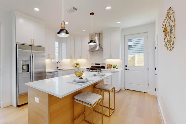 4800 Prock Ln Unit A, Austin, TX 78721 - kitchen with appliances with stainless steel finishes, wall chimney range hood, light wood-style flooring, healthy amount of natural light, and recessed lighting