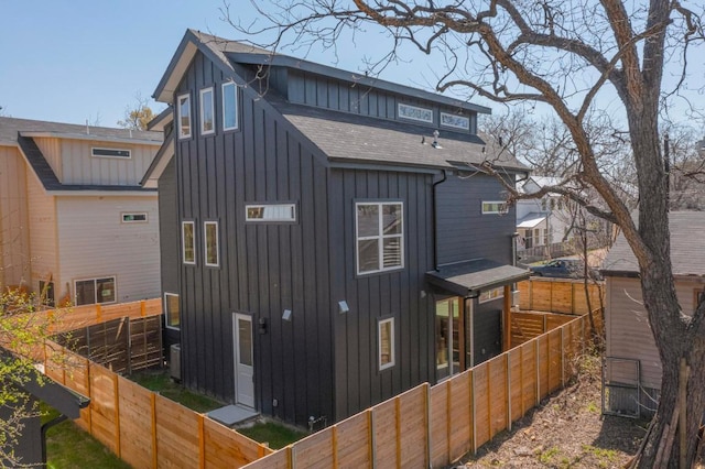 4800 Prock Ln Unit A, Austin, TX 78721 - back of house featuring board and batten siding, a fenced backyard, and roof with shingles