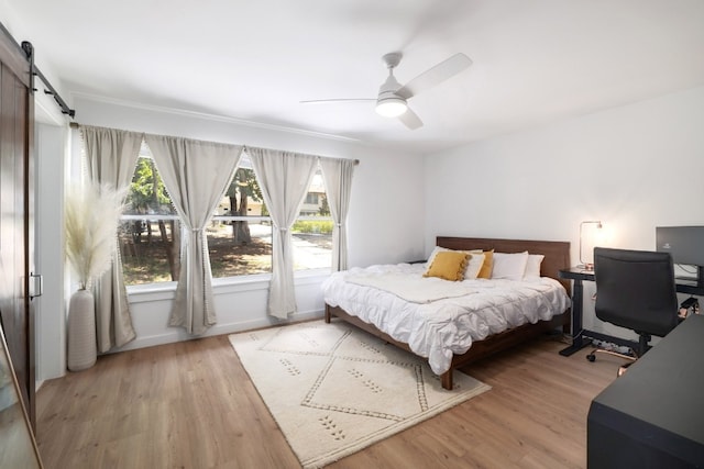 2205 Trede Dr, Austin, TX 78745 - bedroom with wood finished floors, a ceiling fan, baseboards, a barn door, and a desk