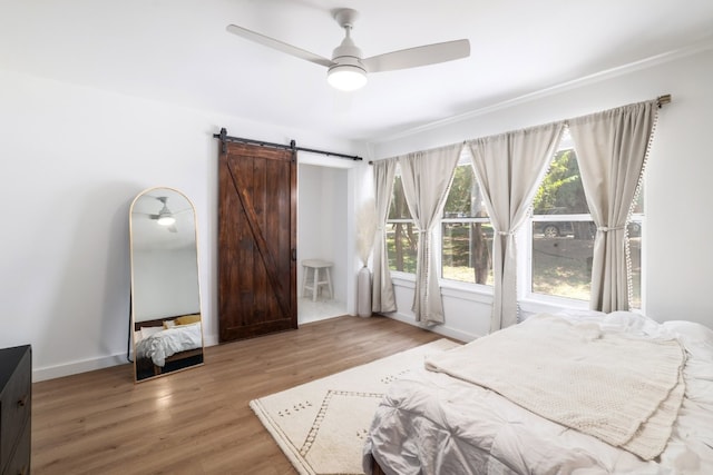 2205 Trede Dr, Austin, TX 78745 - bedroom with a barn door, wood finished floors, and a ceiling fan