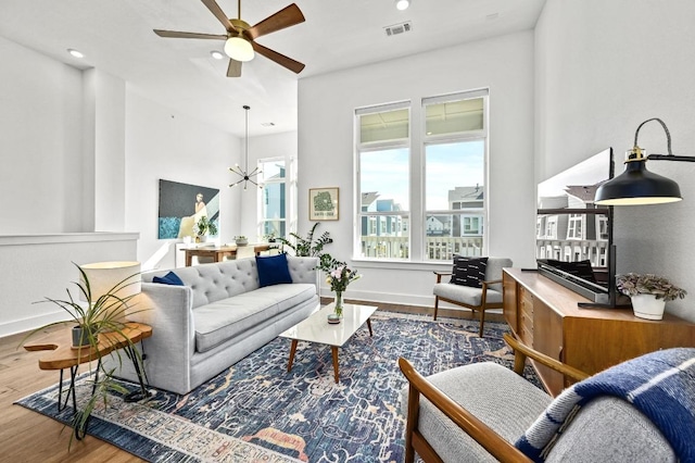 living room with recessed lighting, wood finished floors, ceiling fan with notable chandelier, baseboards, and visible vents