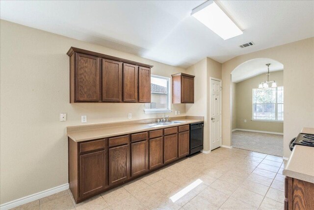 12900 Noche Clara Dr, Del Valle, TX 78617 - kitchen featuring black dishwasher, arched walkways, light countertops, and healthy amount of natural light