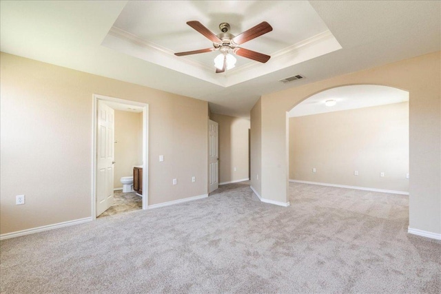 12900 Noche Clara Dr, Del Valle, TX 78617 - unfurnished room featuring a raised ceiling, arched walkways, a ceiling fan, light colored carpet, and ornamental molding