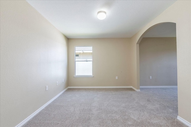 12900 Noche Clara Dr, Del Valle, TX 78617 - unfurnished room with arched walkways, carpet floors, and baseboards