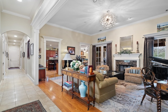 4403 Elohi Dr, Austin, TX 78746 - living room featuring arched walkways, light tile patterned floors, ornamental molding, a fireplace, and a chandelier