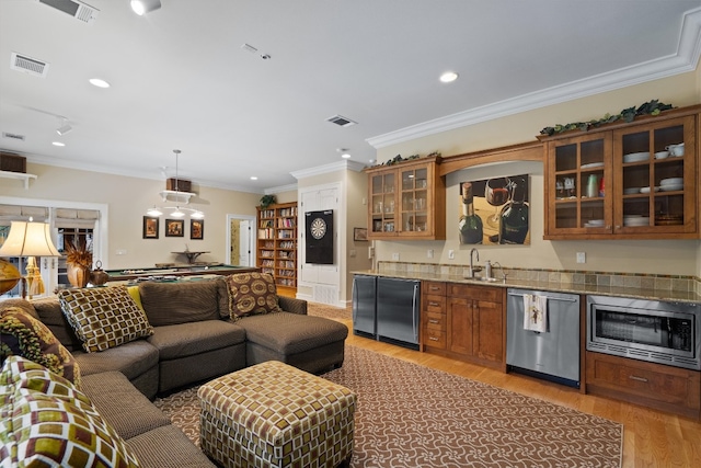 4403 Elohi Dr, Austin, TX 78746 - indoor wet bar with stainless steel appliances, light wood-style floors, recessed lighting, ornamental molding, and decorative light fixtures