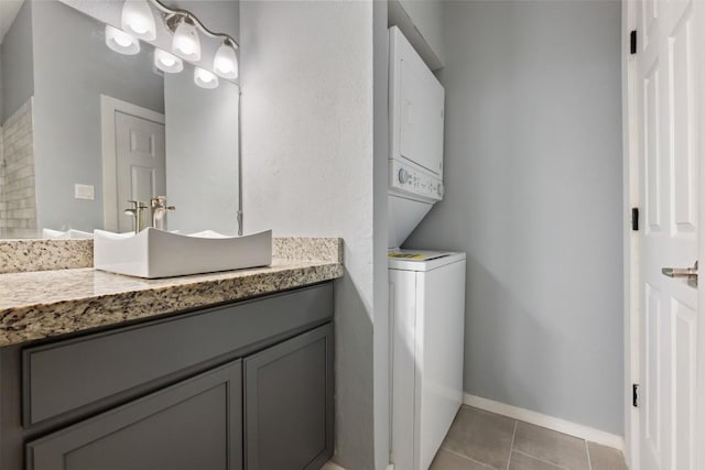 2450 Wickersham Ln Unit 101, Austin, TX 78741 - bathroom featuring estacked washer and dryer, vanity, tile patterned flooring, and baseboards