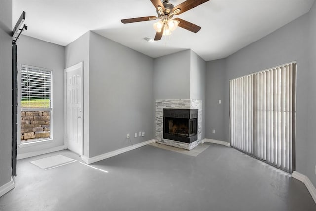 2450 Wickersham Ln Unit 101, Austin, TX 78741 - unfurnished living room with ceiling fan, baseboards, concrete flooring, and a tile fireplace