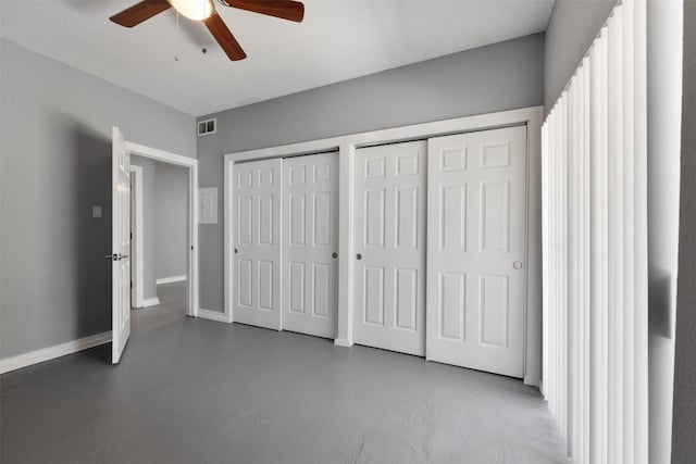 2450 Wickersham Ln Unit 101, Austin, TX 78741 - unfurnished bedroom with visible vents, two closets, baseboards, concrete flooring, and ceiling fan