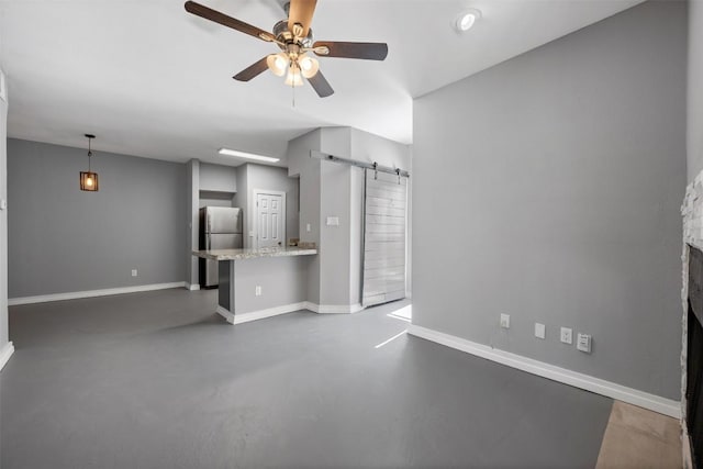 2450 Wickersham Ln Unit 101, Austin, TX 78741 - unfurnished living room featuring a barn door, baseboards, concrete floors, and ceiling fan