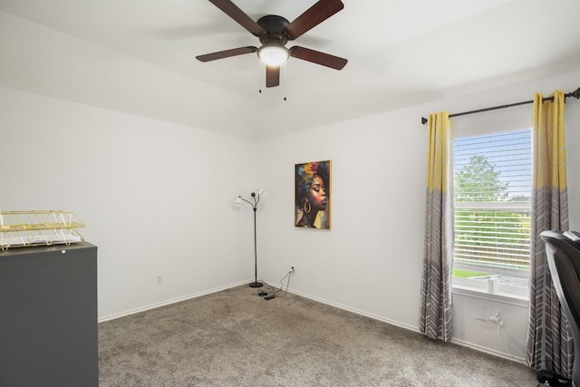 carpeted empty room featuring a ceiling fan and baseboards