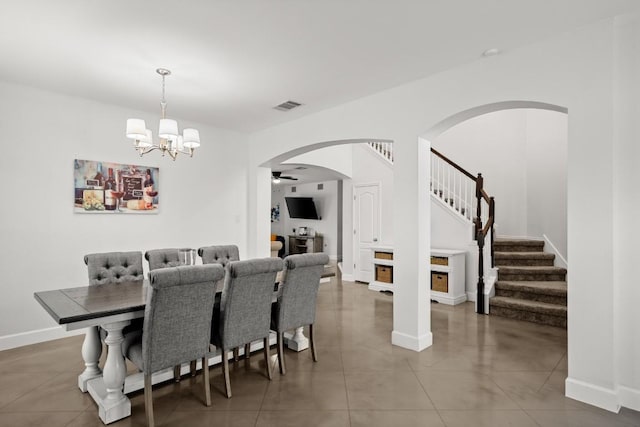 dining space featuring visible vents, baseboards, stairway, arched walkways, and a chandelier