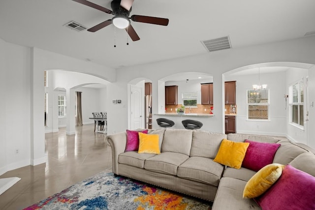 living area with plenty of natural light, ceiling fan with notable chandelier, and visible vents