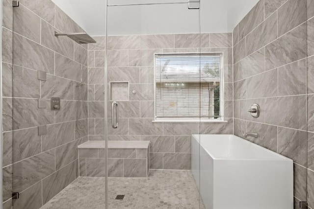 bathroom featuring a washtub and a shower stall