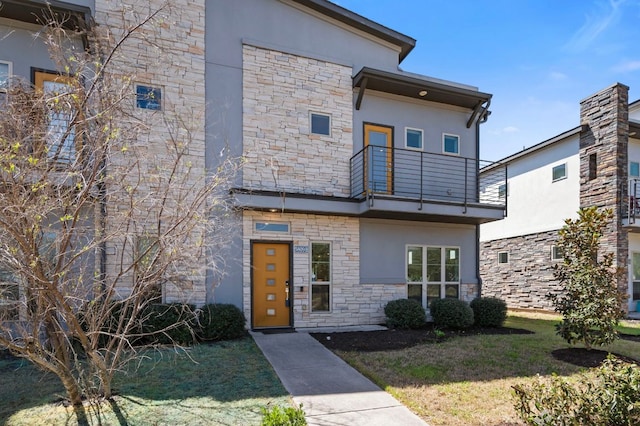 5809 Charles Merle Dr Unit B, Austin, TX 78747 - modern home featuring stone siding, a balcony, stucco siding, and a front lawn