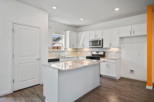 5809 Charles Merle Dr Unit B, Austin, TX 78747 - kitchen with stainless steel appliances, a sink, white cabinetry, dark wood-style flooring, and backsplash