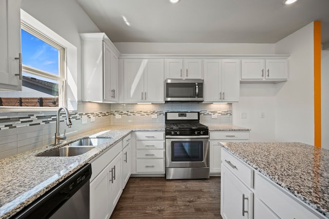 5809 Charles Merle Dr Unit B, Austin, TX 78747 - kitchen featuring stainless steel appliances, a sink, white cabinets, dark wood-style floors, and backsplash