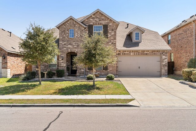 386 Nautical Loop, Kyle, TX 78640 - view of front of home with brick siding, a front lawn, driveway, and an attached garage