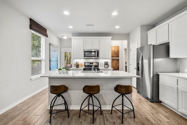 1405 Ambler Dr, Austin, TX 78753 - kitchen featuring stainless steel appliances, light wood-style flooring, light countertops, backsplash, and recessed lighting