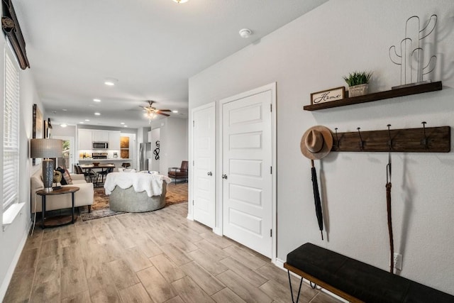 living area with recessed lighting, light wood-type flooring, and ceiling fan