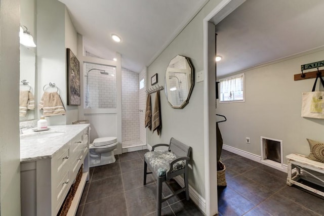 full bathroom with tile patterned floors, a tile shower, vanity, vaulted ceiling, and toilet