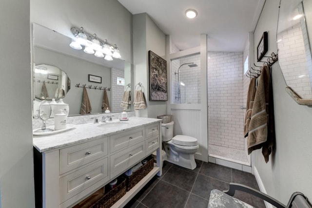 bathroom with toilet, tile patterned flooring, a stall shower, and vanity