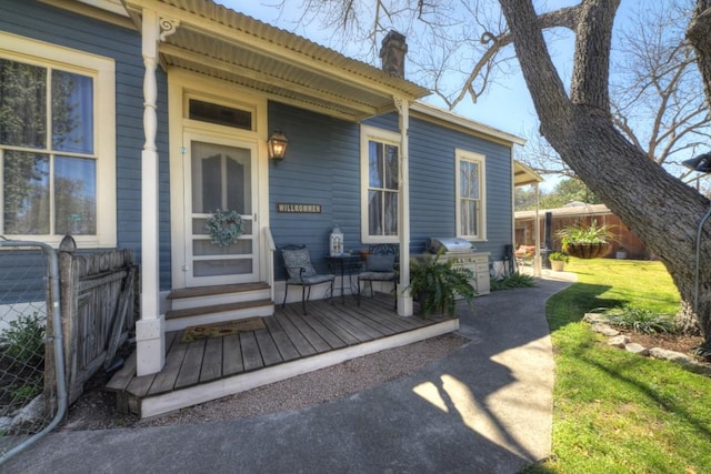 doorway to property featuring a chimney and fence